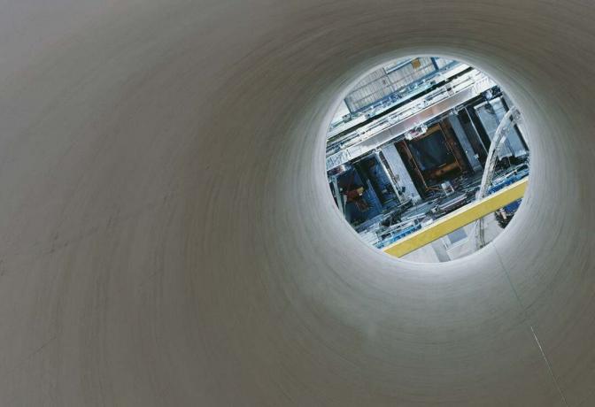 ששת הניסויים של ה-LHC ממוקמים עמוק מתחת לפני כדור הארץ ומבודדים מפני עולם שופע עם הפרעות רדיואקטיביות, מה שהופך את זה לא קל להעמיס את כל הציוד העצום למקומו. הרכיבים של כל ניסוי הורדו מאות מטרים מתחת לפני האדמה דרך מנהרות ענק כמו זו.
