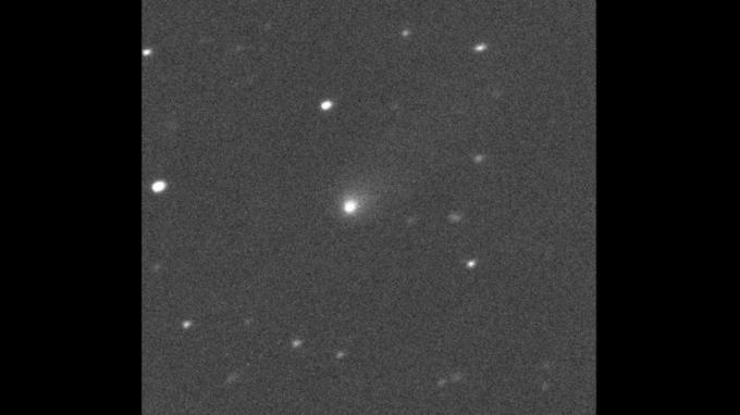 תמונה של אובייקט לבן מטושטש על שדה אפור כהה מנומר בכוכבים.