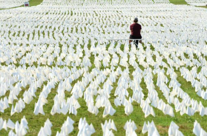 Egy nő fehér zászlókat néz a National Mall bevásárlóközpontjában 2021. szeptember 18-án Washington DC-ben. Több mint 660 000 fehér zászlót helyeztek el itt a COVID-19 miatt életüket vesztett amerikaiak tiszteletére. 
