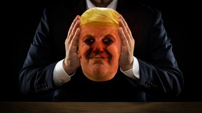 Sjenovita figura drži masku Donalda Trumpa.
